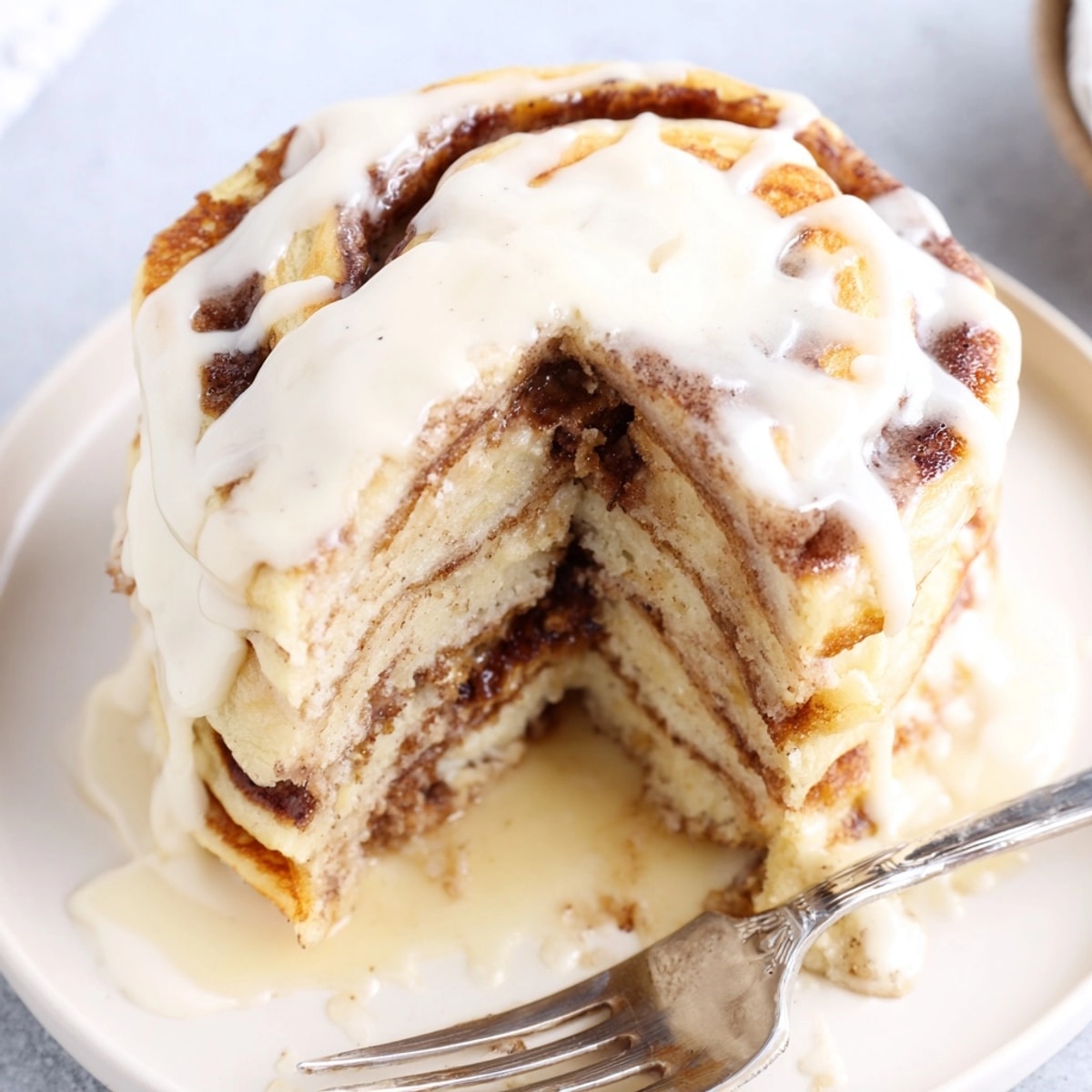 Golden Cinnamon Roll Pancake Bake fresh from oven, drizzled with sweet cream cheese glaze.