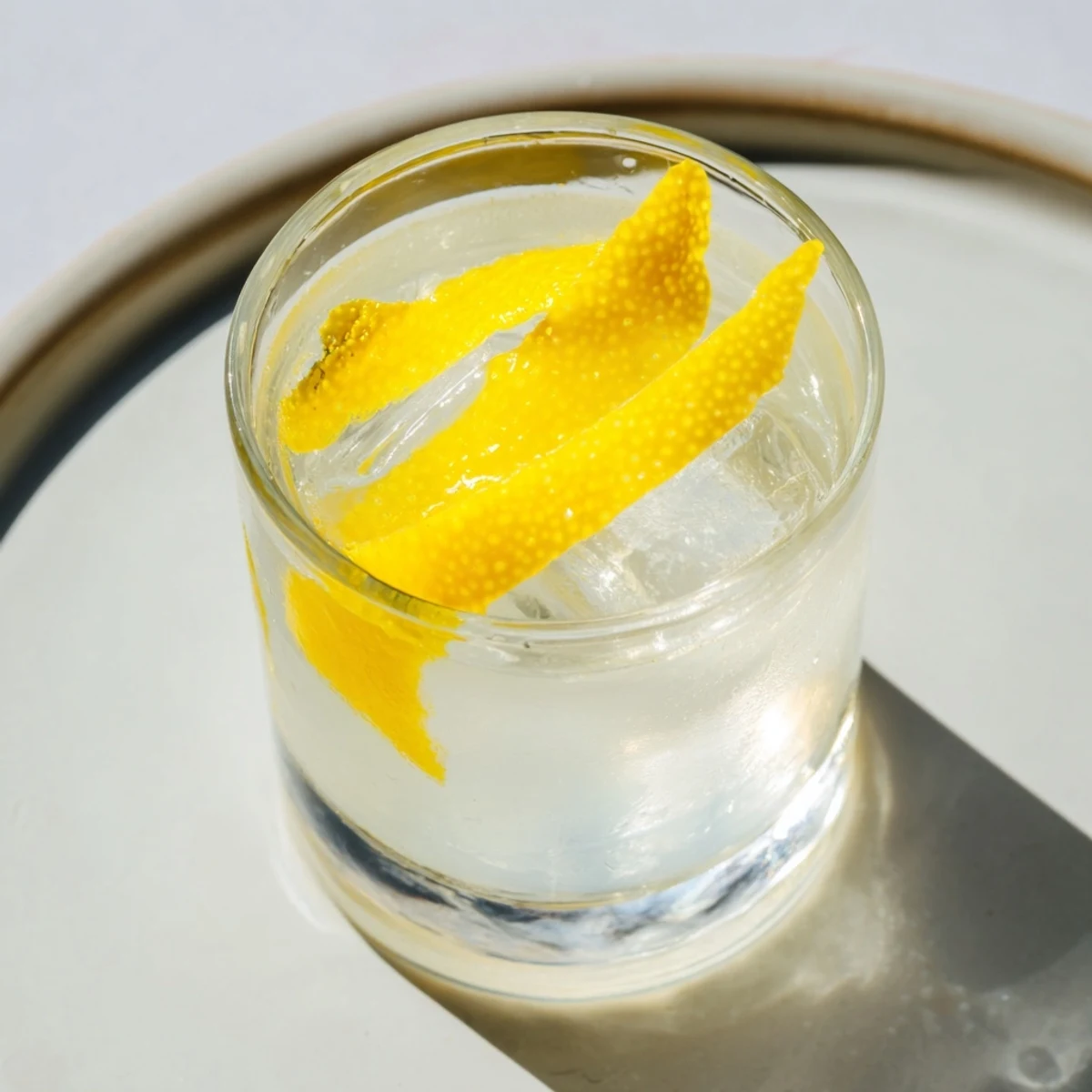 A chilled Lemon Twist cocktail, garnished with bright lemon peel, ready to be enjoyed.