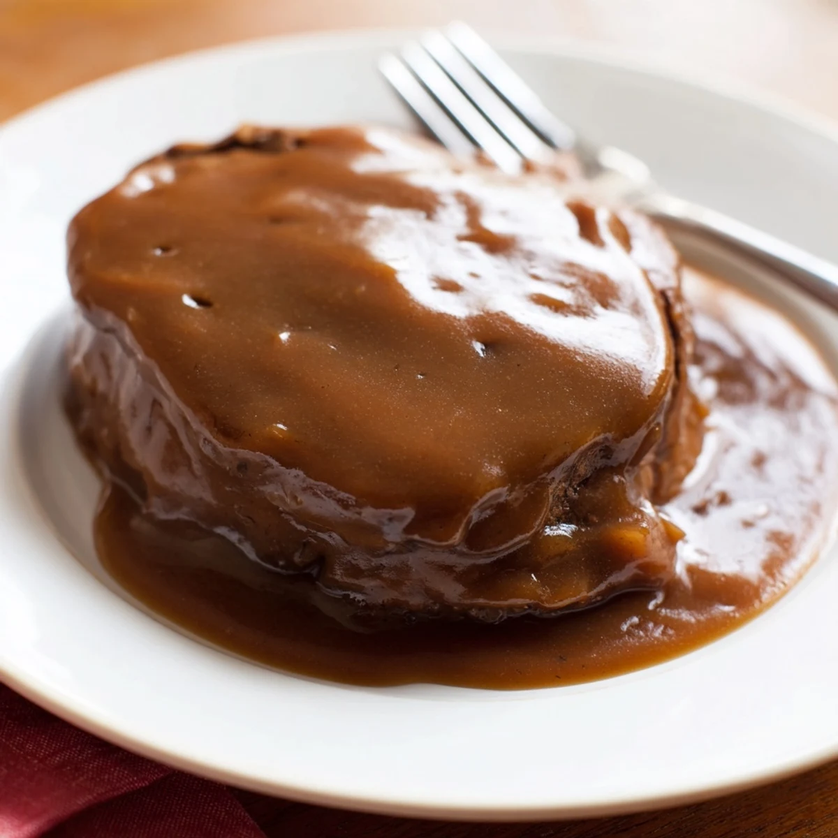 Golden, simmering beef gravy in a saucepan, ready to thicken into a delicious sauce for dinner.