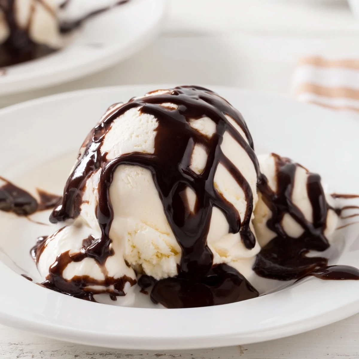 Warm, glossy chocolate syrup pouring onto a stack of fluffy pancakes for breakfast.