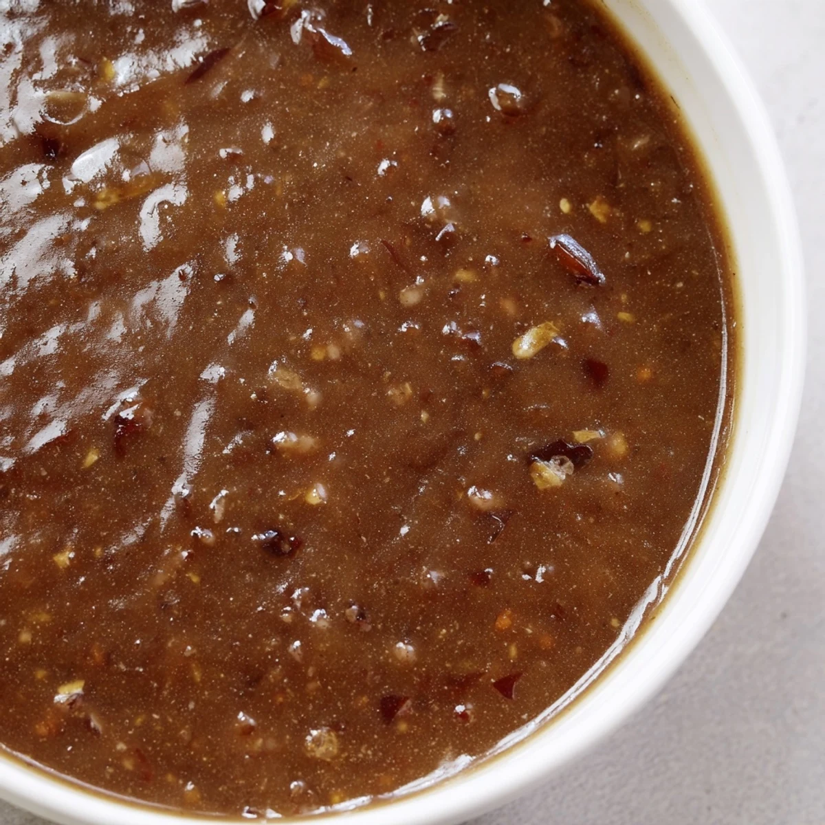 A rich, dark savory gravy ready to be ladled over a helping of juicy roast chicken.