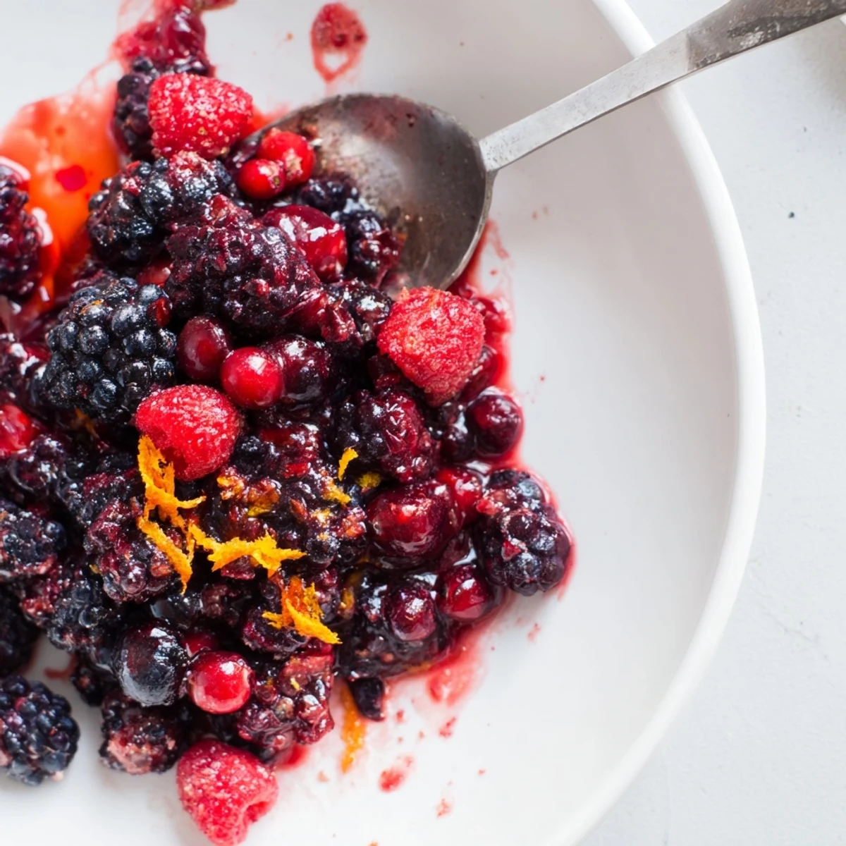 Vibrant Winter Berry Compote, warm and glistening, ready to spoon over fluffy pancakes.