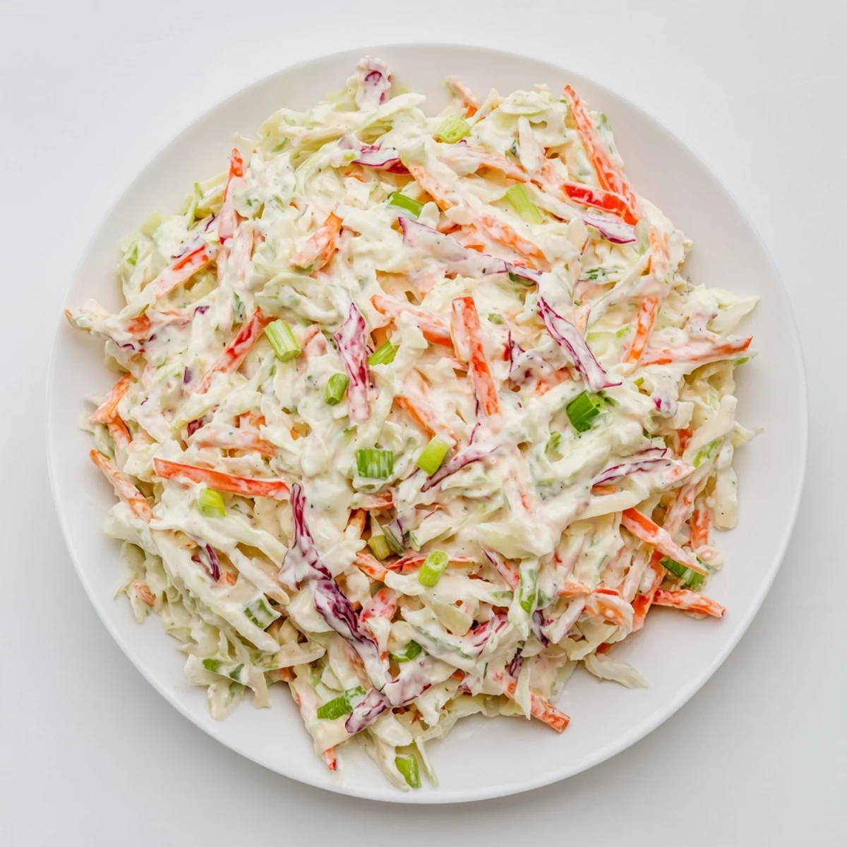 Close-up of creamy coleslaw salad: tangy dressing coating crisp vegetables for a flavorful side.