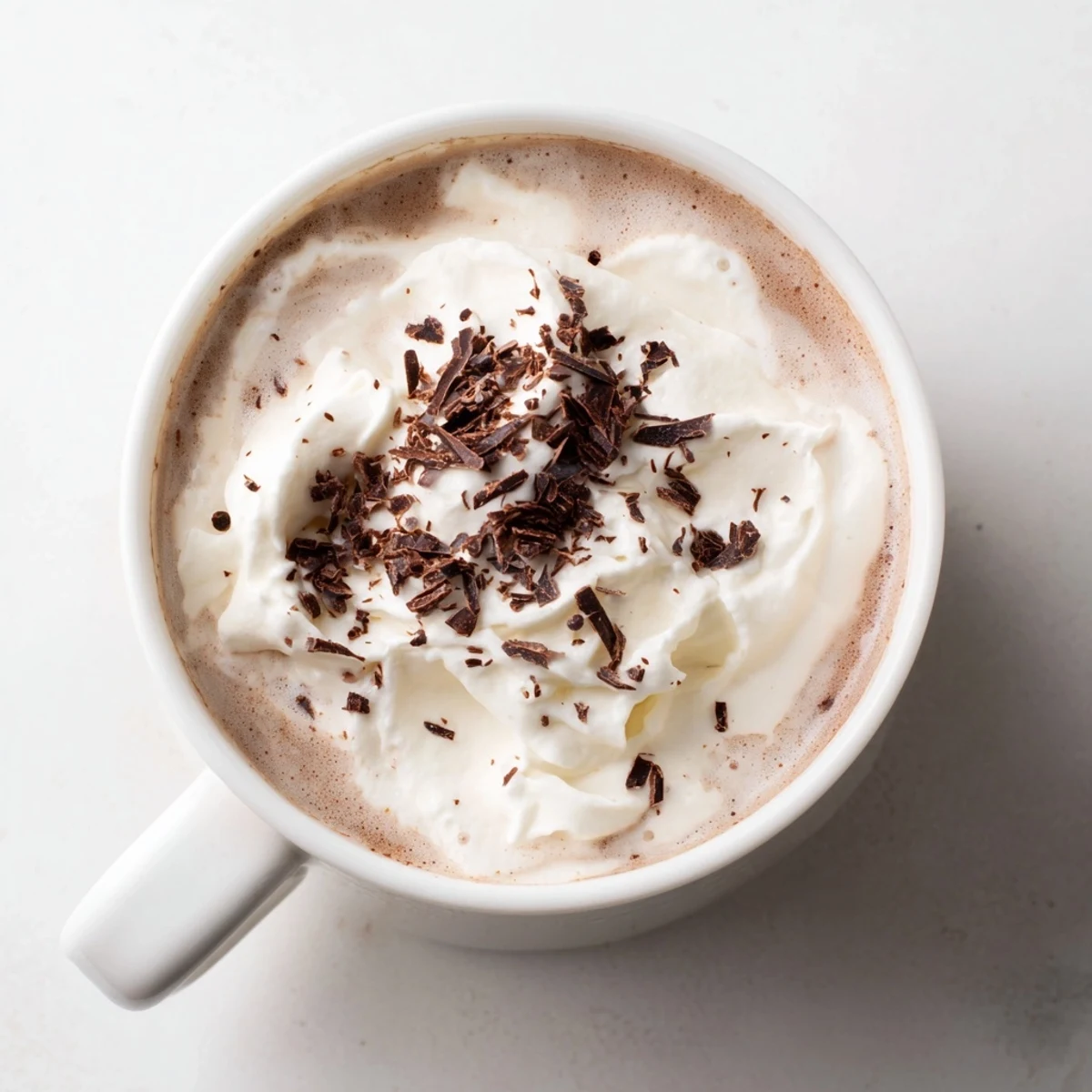 Steaming mugs of hot chocolate, garnished with whipped cream, perfect for a cozy evening.