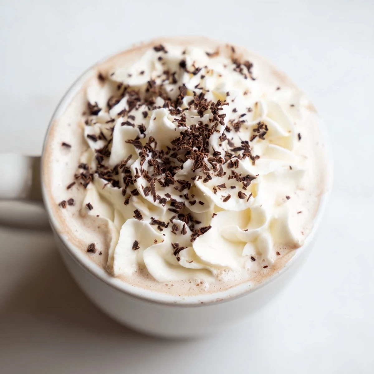 Luscious, dark hot chocolate topped with pillowy marshmallows and chocolate curls, ready to sip.