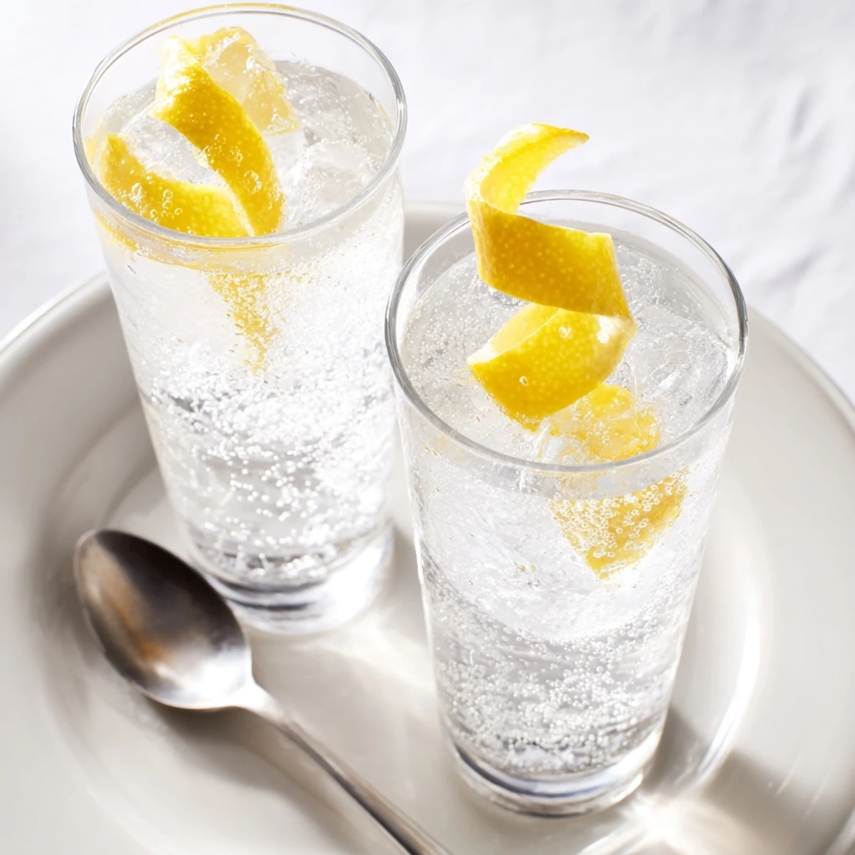 Bright and bubbly Twist Lemon mocktail, garnished with a sunny lemon twist, a perfect summer refresher.