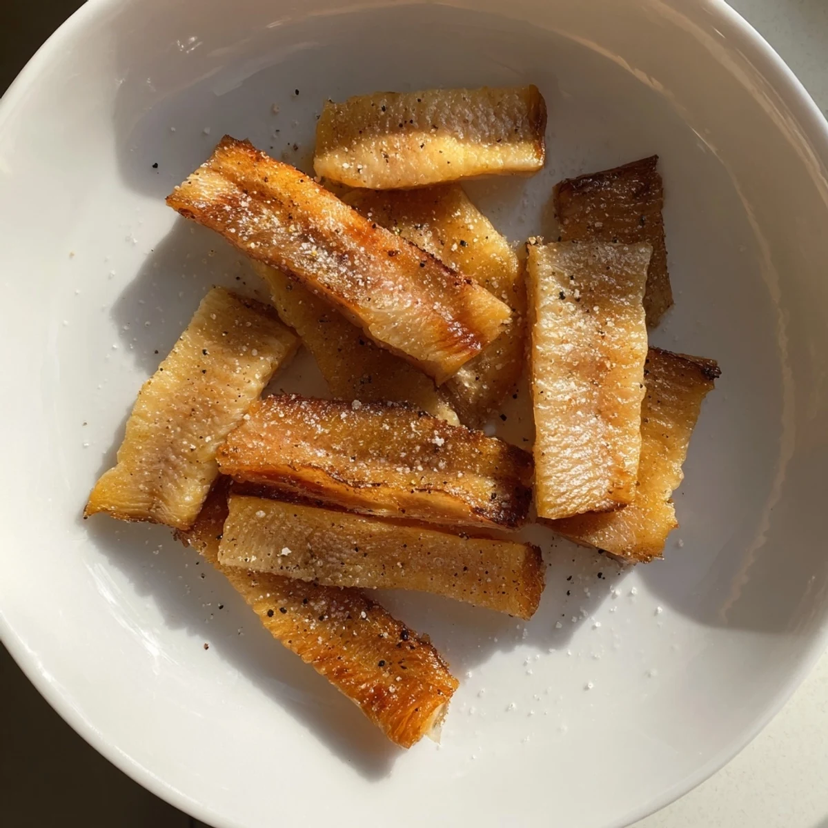 Close-up image shows perfectly seasoned and baked crispy salmon skin chips, a flavor explosion.