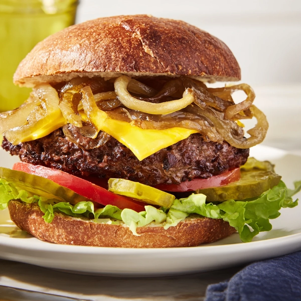 A close-up of delicious beef burgers showcasing golden caramelized onions with all the fixings.