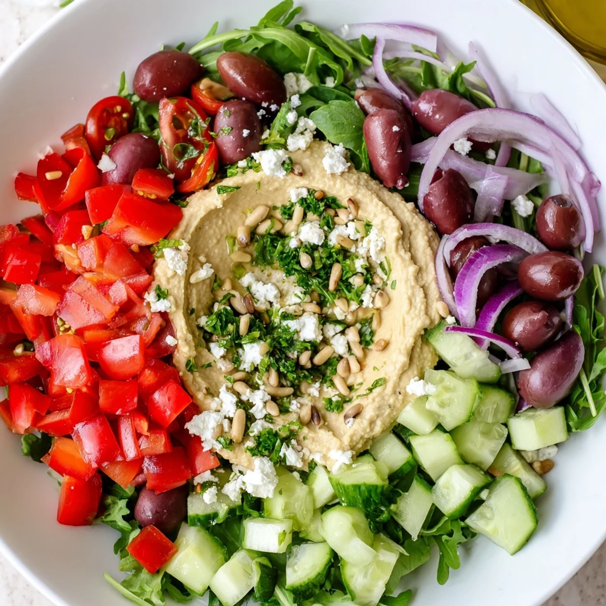 Bright, vibrant image of Mediterranean Salad with Hummus, drizzled with dressing, ready to eat.