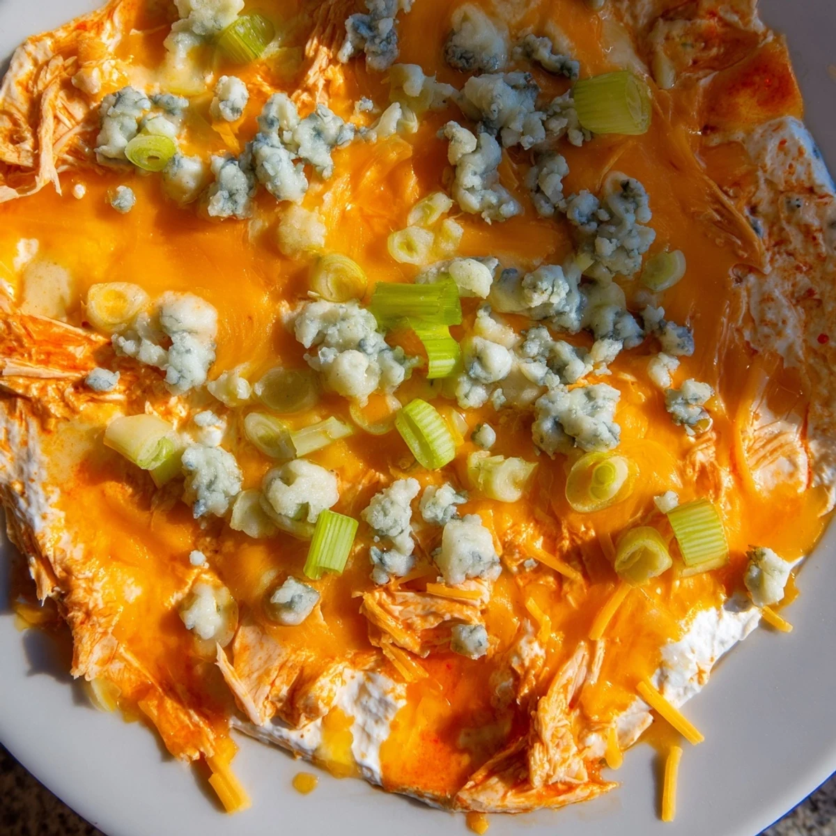 Creamy, zesty Spicy Buffalo Chicken Dip in a baking dish with crunchy celery and chips, perfect for game day.