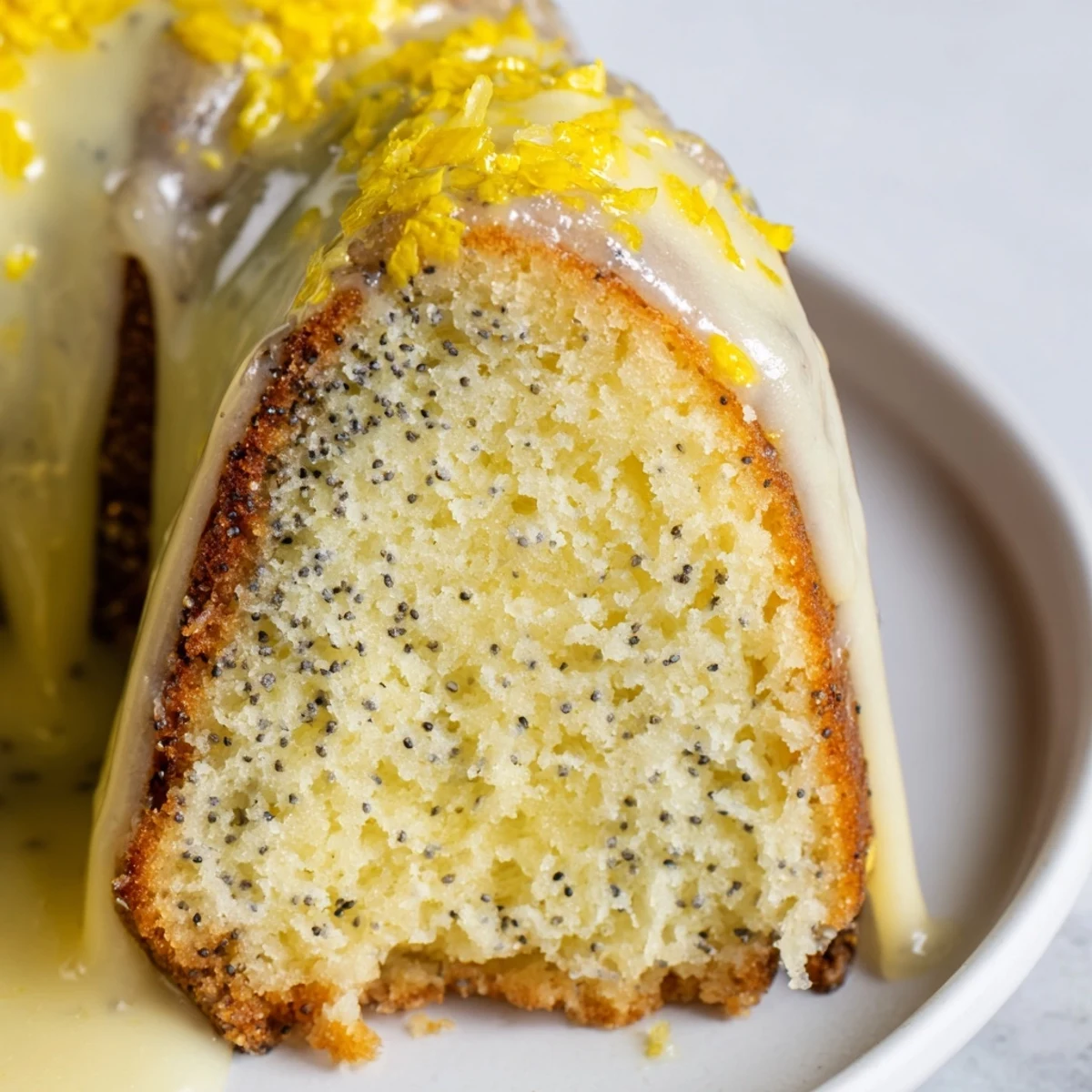 Bright lemon glaze drips down the textured surface of this moist Lemon Poppy Seed Bundt Cake.