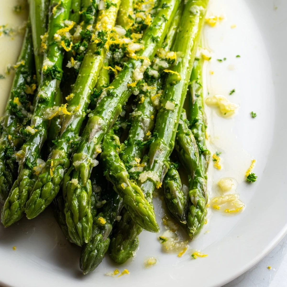 Bright green asparagus sautéed with garlic and butter, finished with a bright squeeze of lemon juice and fresh parsley garnish.