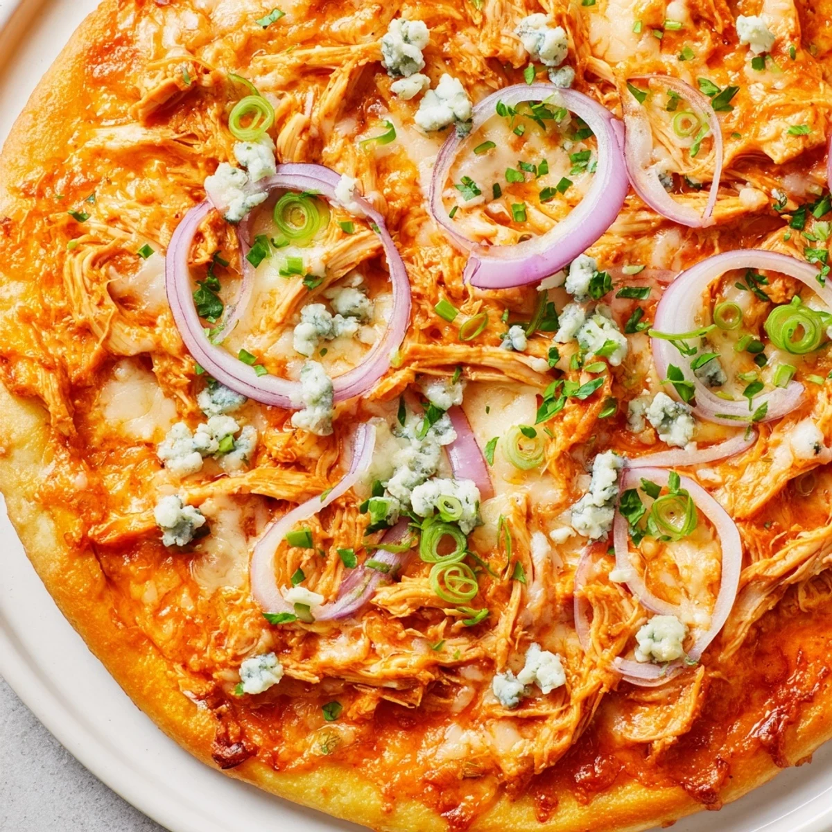 A serving of MVP Buffalo Chicken Pizza with blue cheese, paired with ranch dressing and a cold lager.