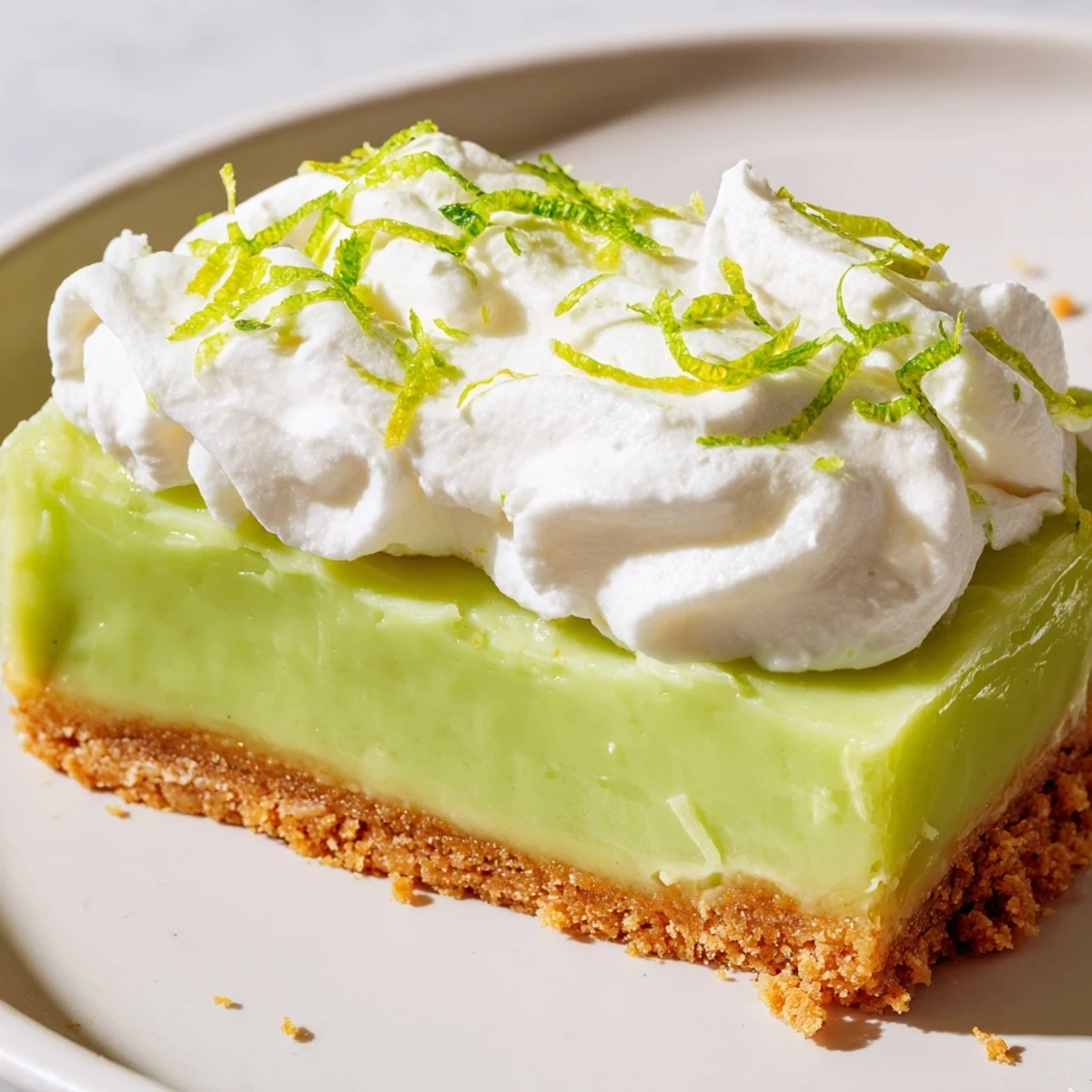 Freshly baked St. Patricks Day Key Lime Pie Bars with a bright green filling sit on a cooling rack.