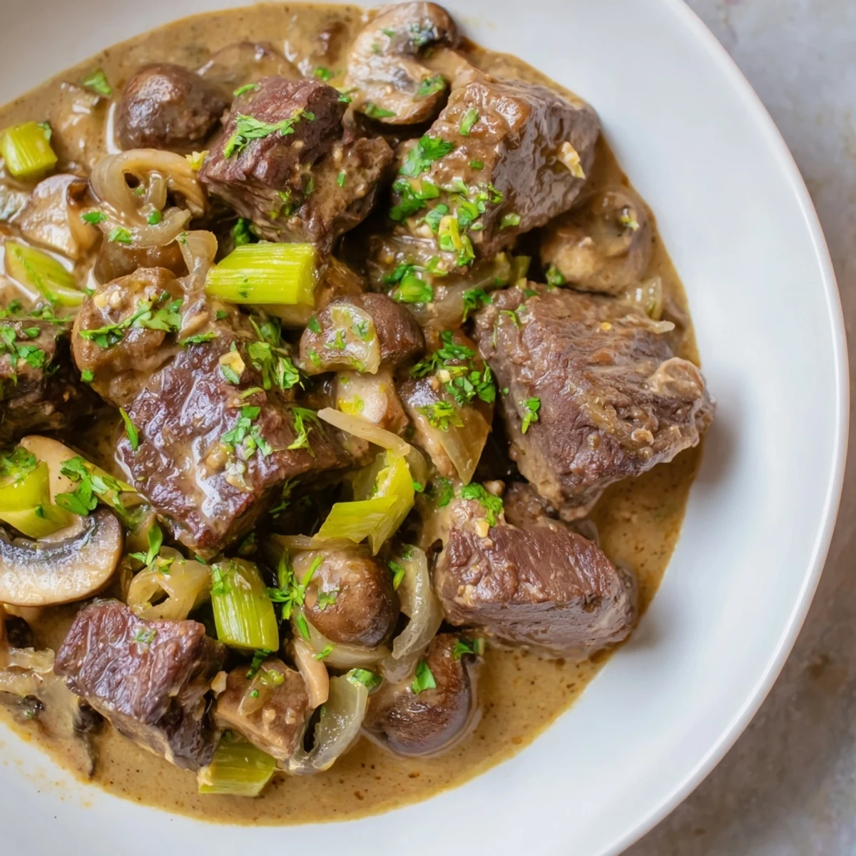 Tender beef cubes coated in coconut milk sauce and garnished with fresh cilantro.