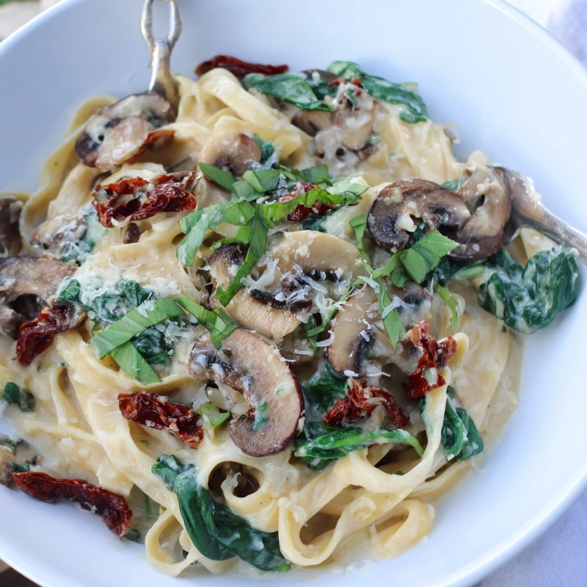 Close-up of Creamy Tuscan Mushroom Pasta Skillet with spinach and sun-dried tomatoes in sauce