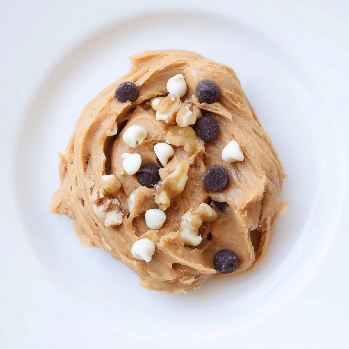Spoonful of Guilt Free Greek Yogurt Cookie Dough being lifted, revealing a thick, dough-like consistency and specks of vanilla.
