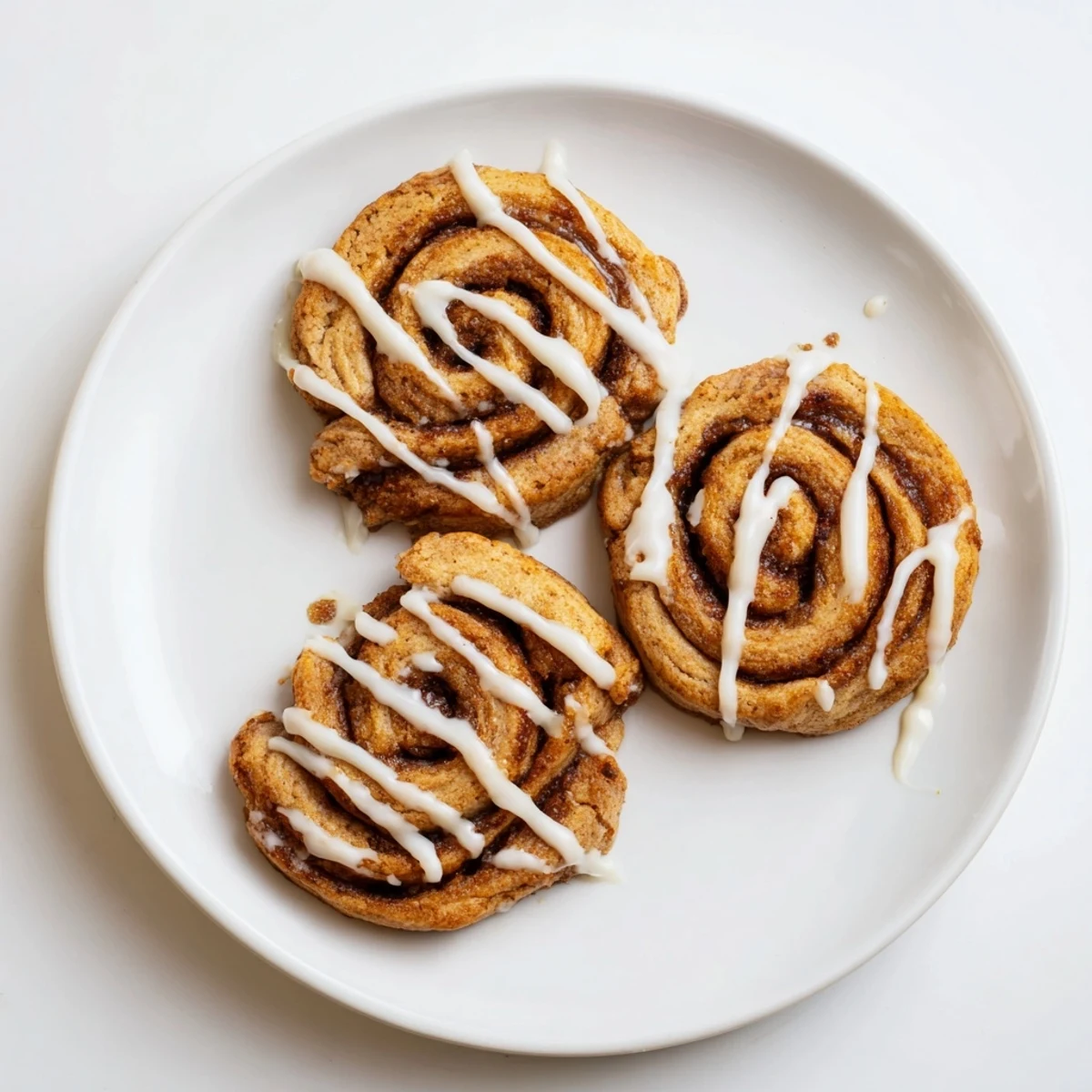 Warm Cinnamon Roll Cookies are plated with a cup of coffee, offering a cozy dessert for an afternoon snack.