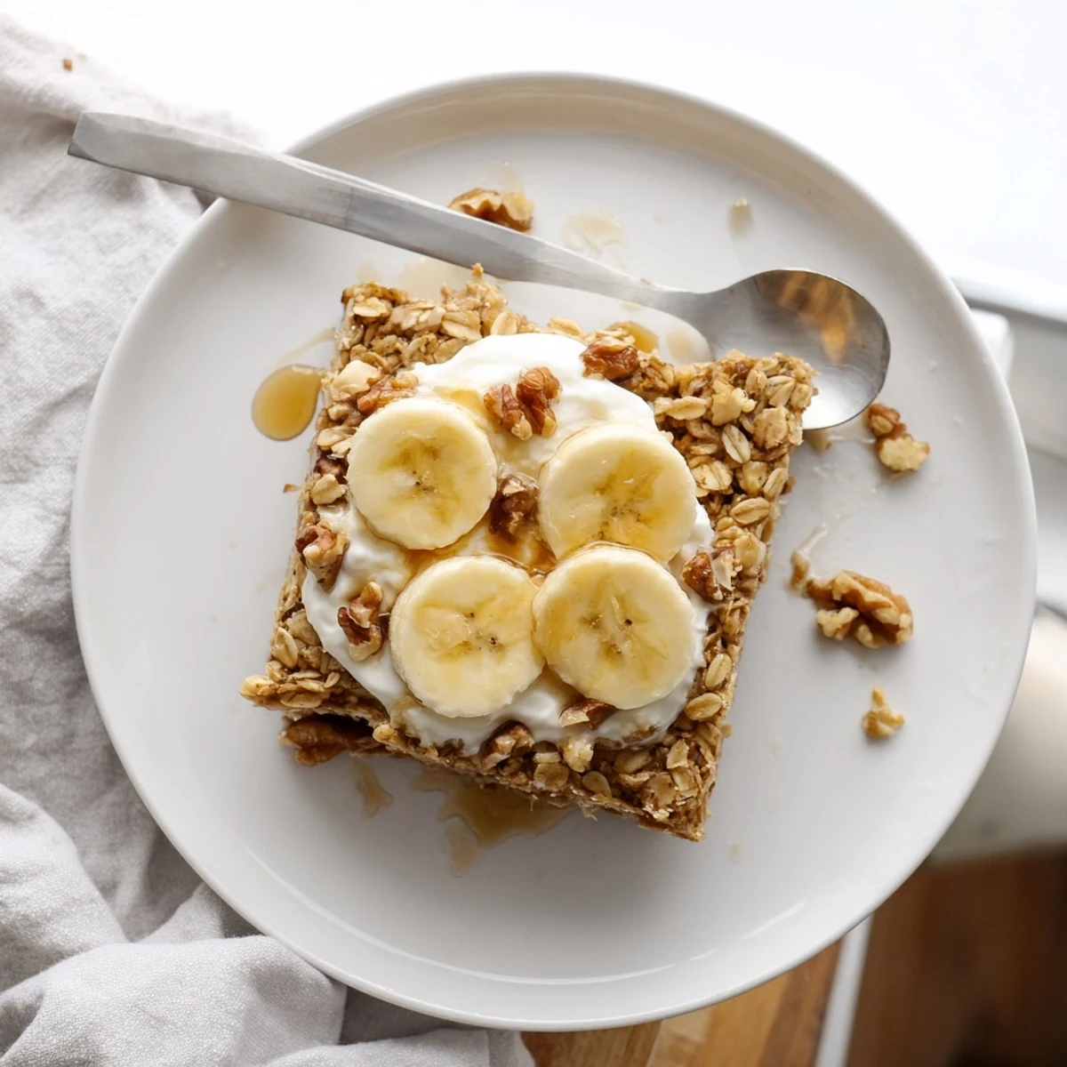 Golden brown Banana Baked Oatmeal fresh from the oven, served with a dollop of Greek yogurt topping.
