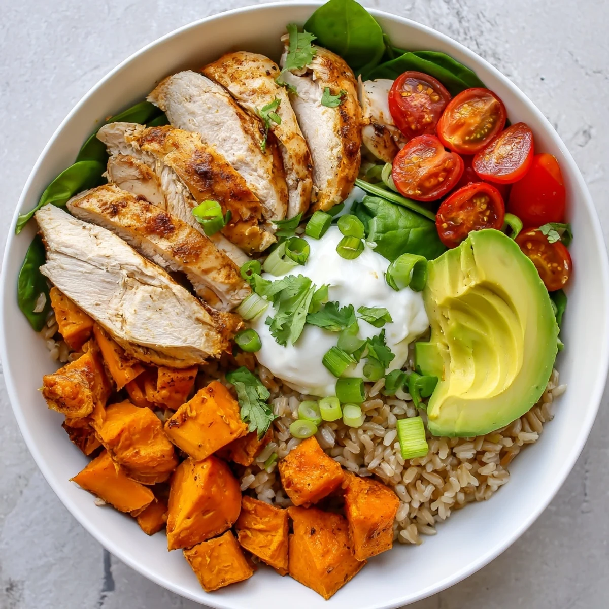 A vibrant serving of Wholesome Chicken Sweet Potato Rice Bowl with roasted sweet potatoes, sliced chicken, and fresh avocado on fluffy rice.