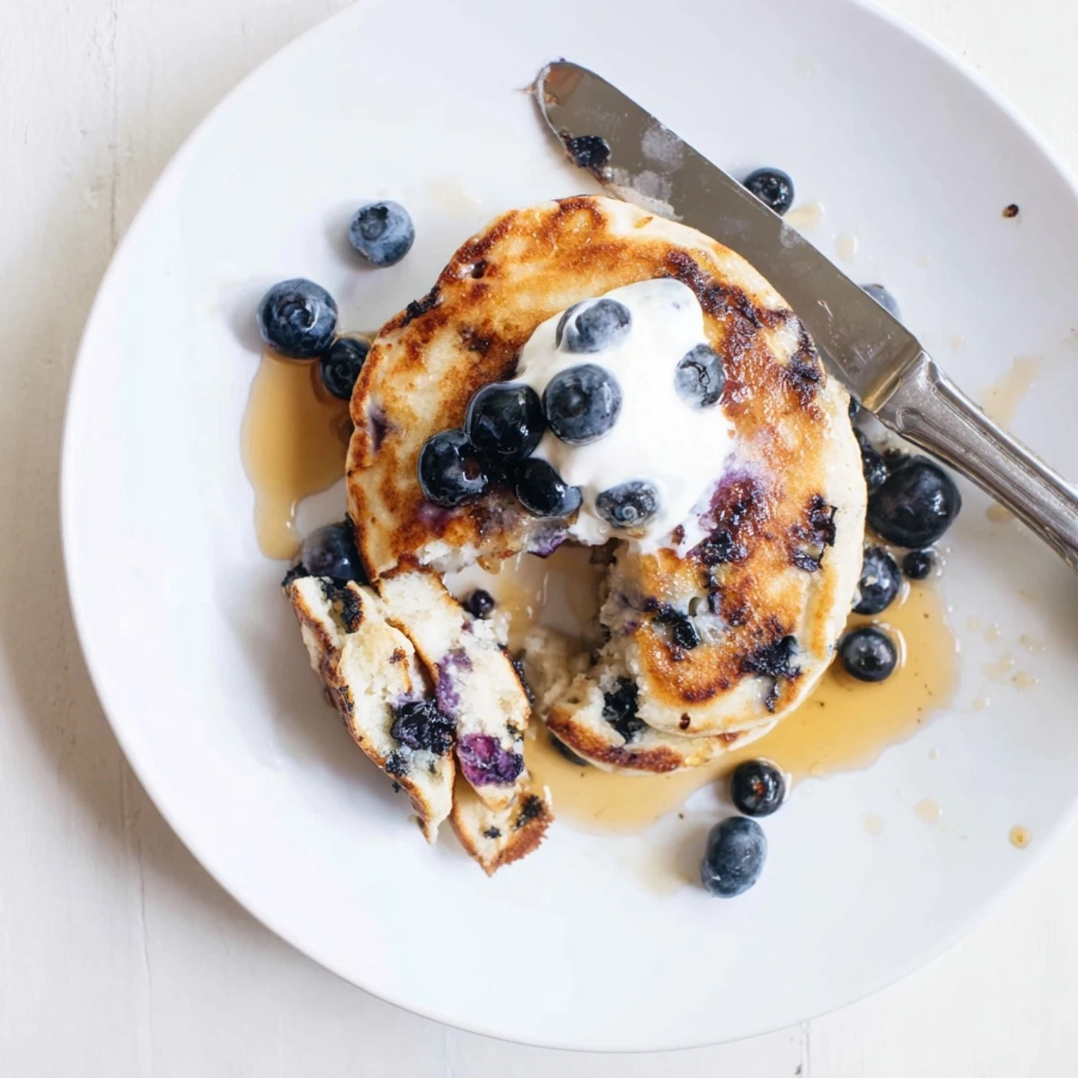 Thick Greek Yogurt Blueberry Pancakes sizzle on a griddle, blueberries burst, tangy aroma filling the morning kitchen.