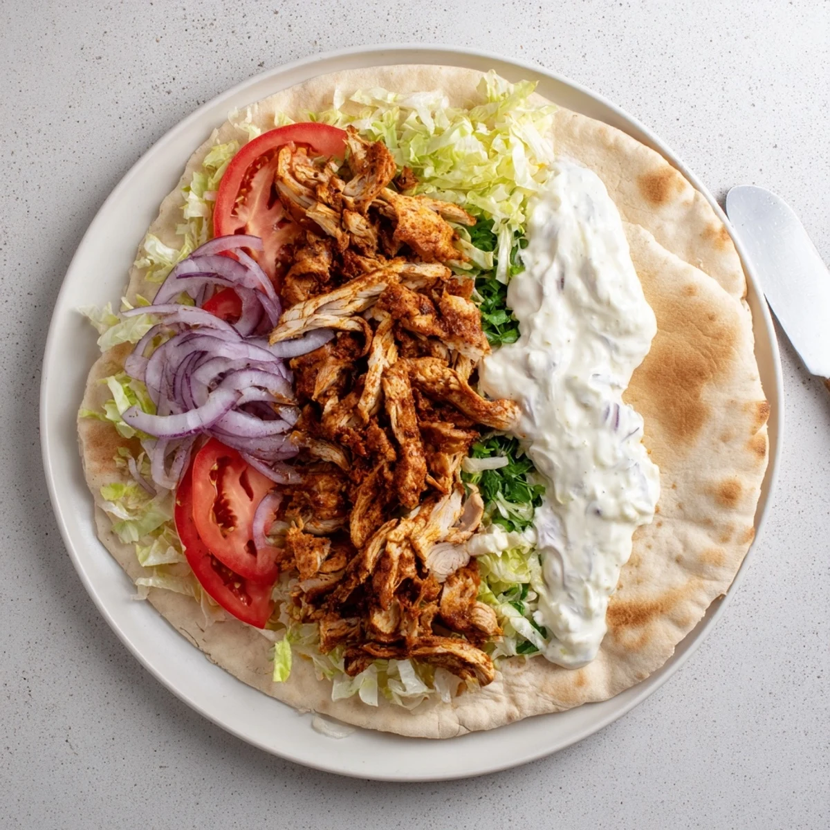Tender marinated chicken shawarma grilled to perfection with aromatic spices and served alongside a zesty homemade garlic dipping sauce.
