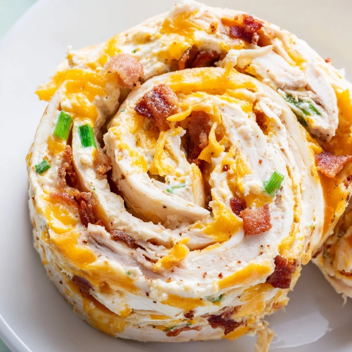 Creamy crack chicken pinwheels spiral with melted cheddar and crispy bacon bits