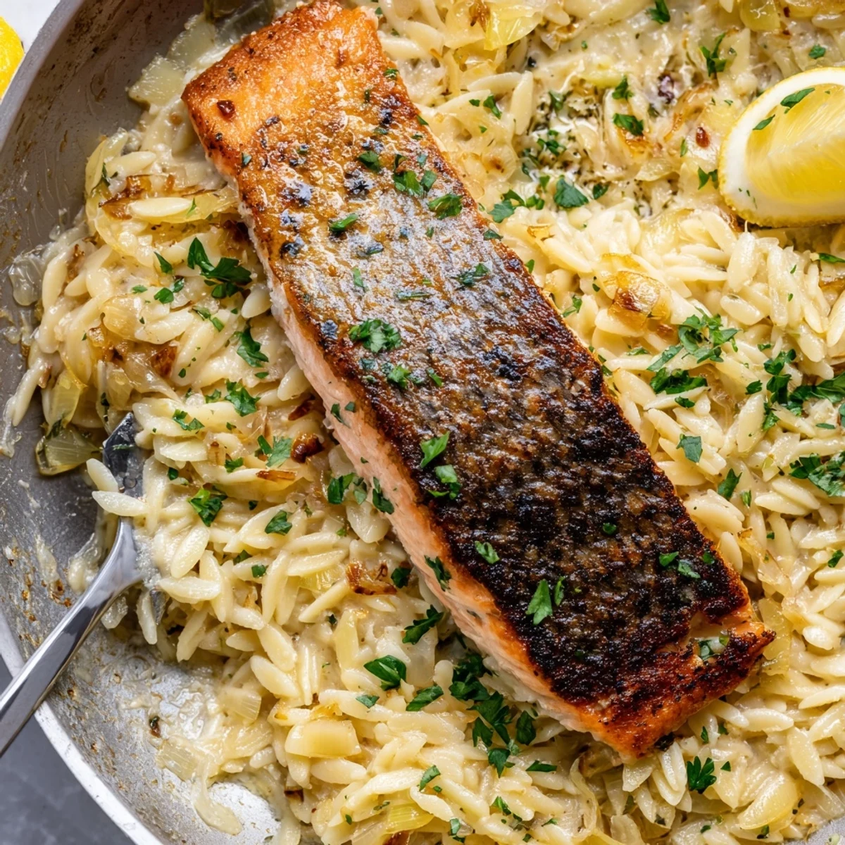 One skillet salmon with lemon orzo garnished with fresh parsley and parmesan