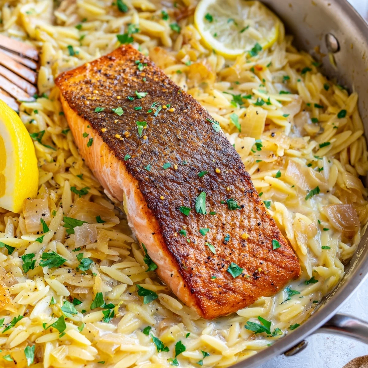 Flaky salmon nestled atop zesty orzo pasta in this one pan meal