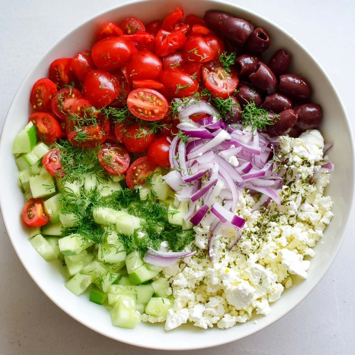 Creamy cottage cheese bowl loaded with Mediterranean Greek salad ingredients including red peppers, Kalamata olives, and herbs