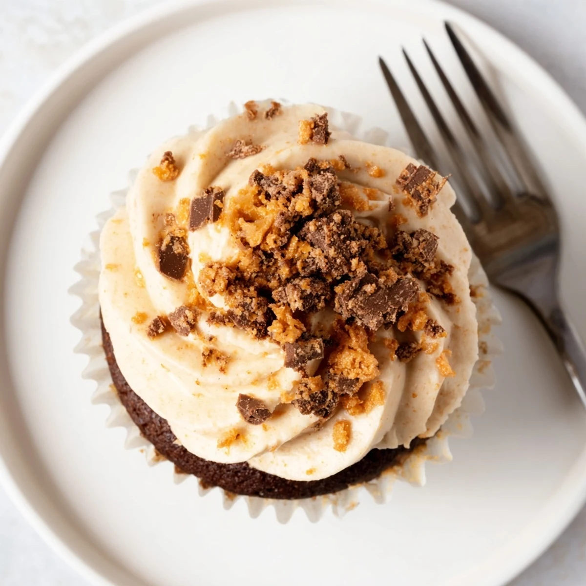 Decadent Butterfinger cupcakes with swirled peanut butter frosting and crushed candy topping
