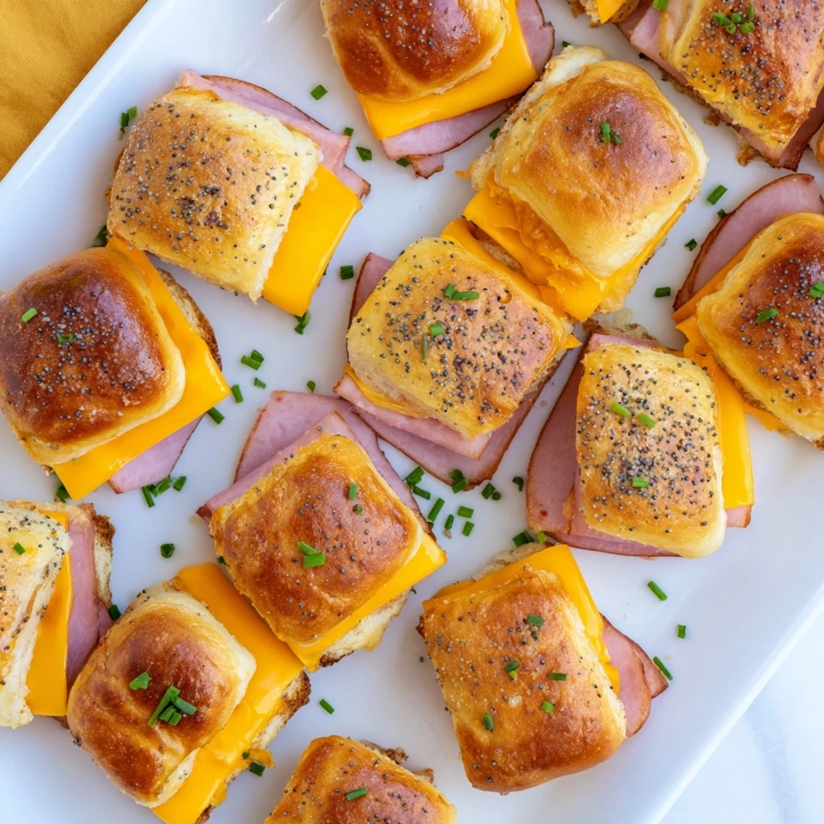 Golden brown sweet savory mini grilled cheese Hawaiian rolls with melted cheddar and honey mustard glaze