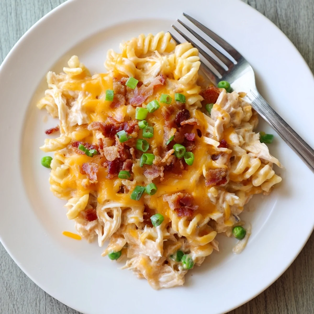 Creamy Crock Pot Crack Chicken Casserole topped with melted cheddar and crispy bacon crumbles