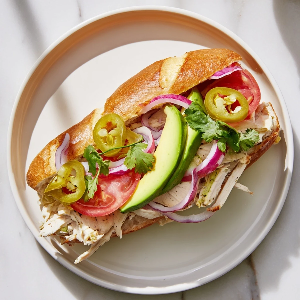 Mexican-style Chicken Torta Sandwich featuring spiced grilled chicken, refried beans, and fresh toppings on soft white bread