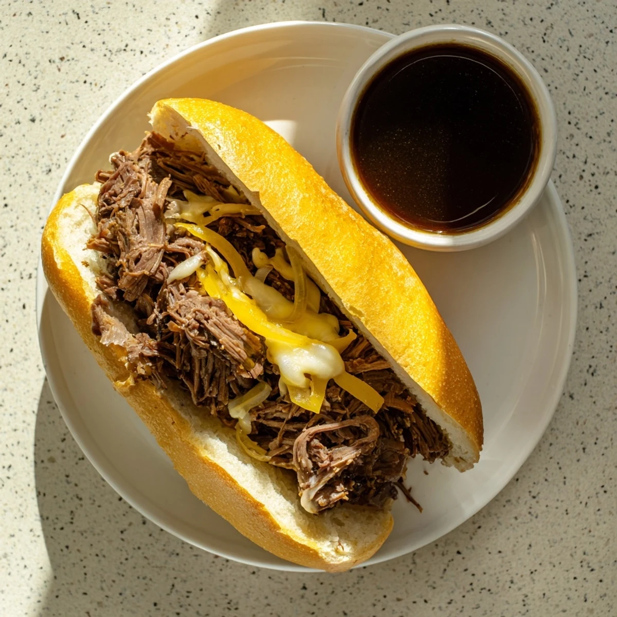 Crockpot French Dip Sandwiches featuring tender shredded beef piled onto toasted hoagie rolls with melted cheese