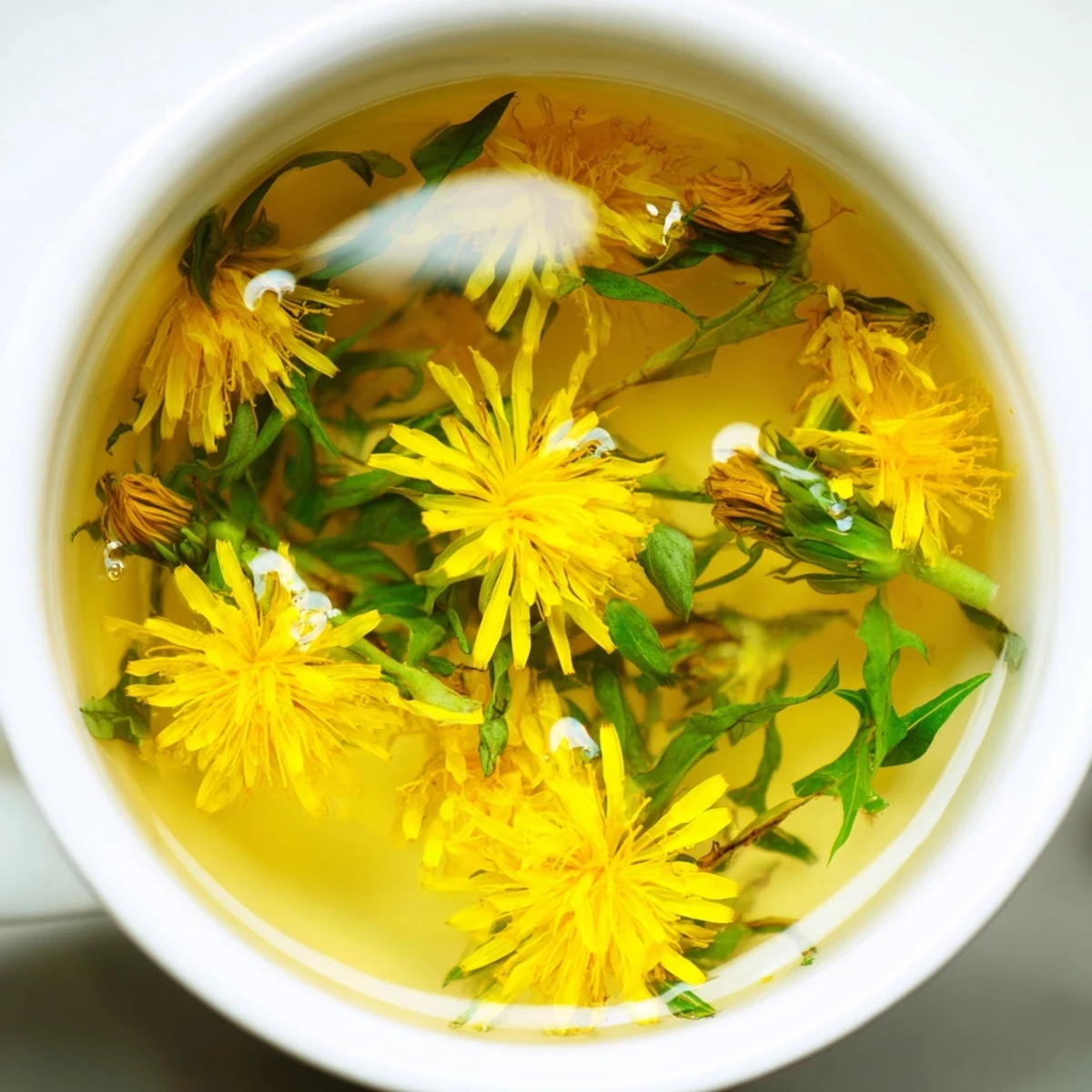 Clear glass of earthy dandelion infusion with honey drizzle and whole blossoms on wooden serving tray