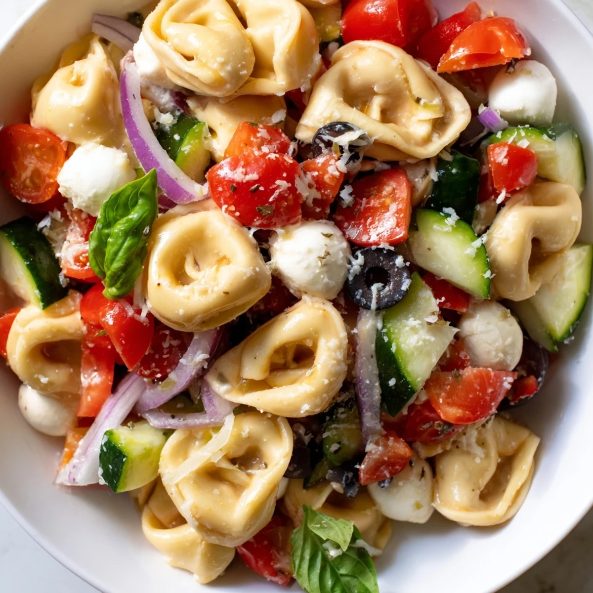 Colorful tortellini salad with cherry tomatoes, cucumber, and mozzarella tossed in zesty Italian dressing
