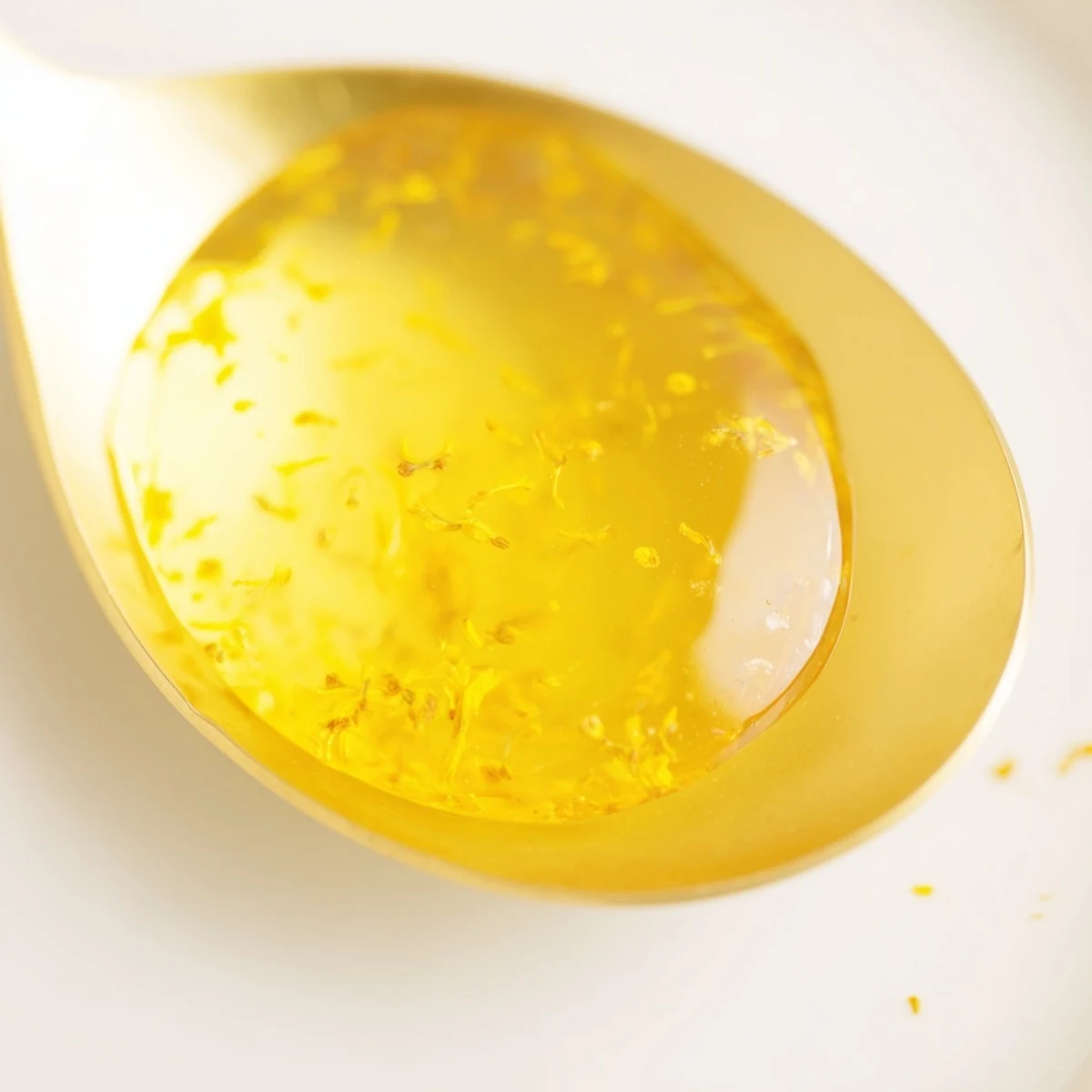 Golden homemade dandelion jelly spread on a slice of toasted artisan bread