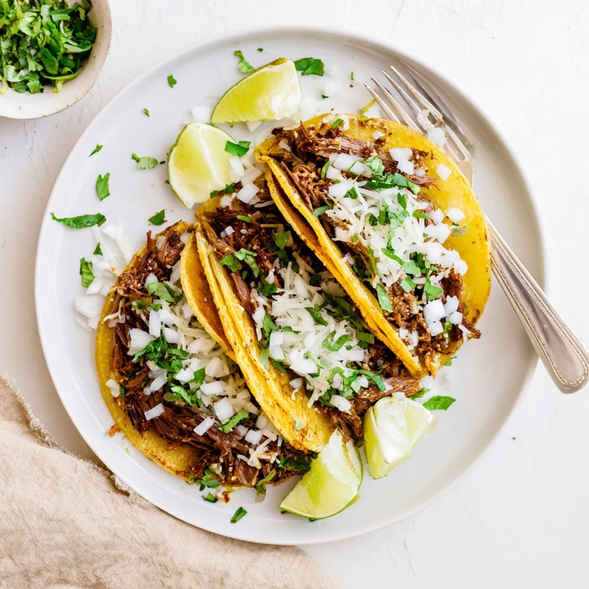 Crispy slow cooker birria tacos loaded with shredded beef, onion, and cilantro.
