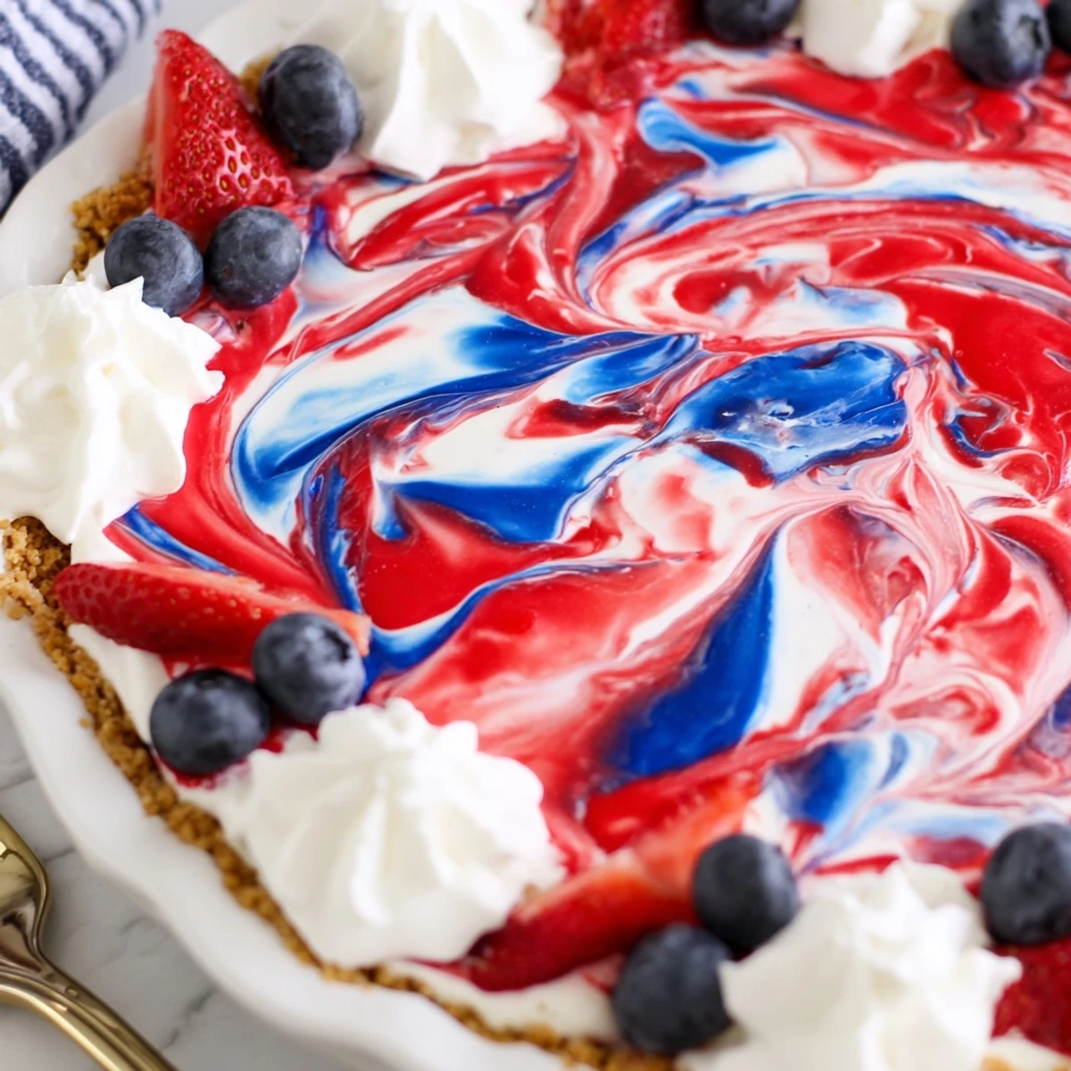 Sliced Patriotic Red White And Blue Swirl Pie topped with whipped cream