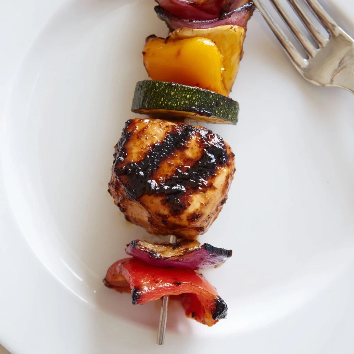 Smoky Chicken Kabobs On The Grill threaded with peppers, onions, lemony glaze