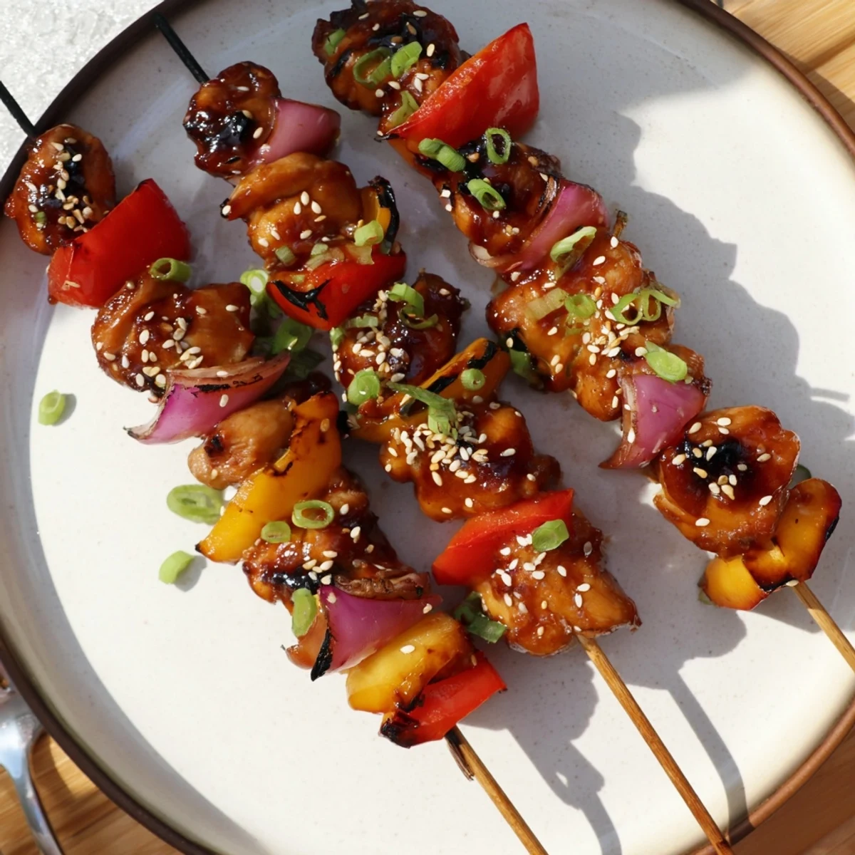 Colorful Chicken Skewers With Korean BBQ Sauce resting on a steaming bed of rice.