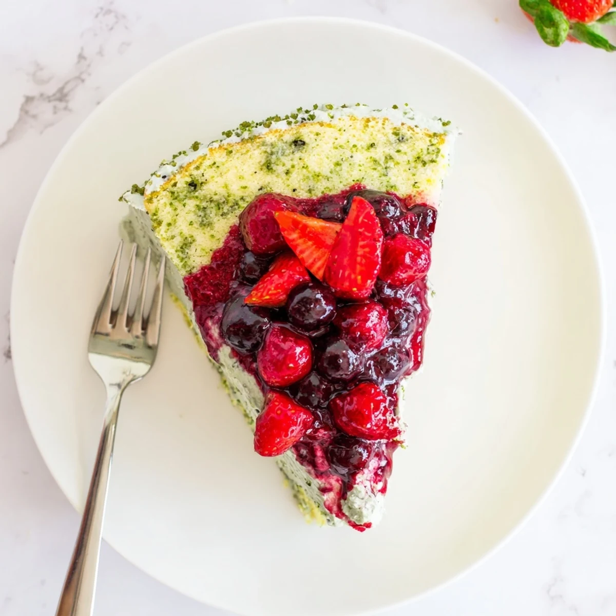 Elegant basil berry cake with whipped cream and glossy mixed berry topping for special occasions