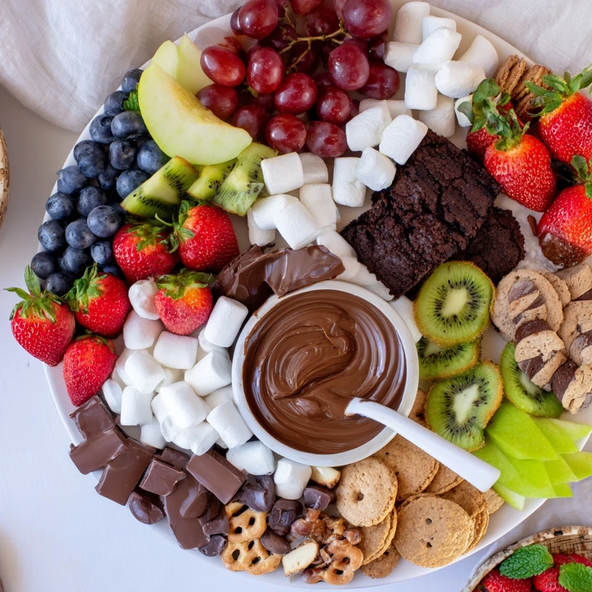 Bright Dessert Charcuterie Board arranged for sharing, mint sprigs and caramel.