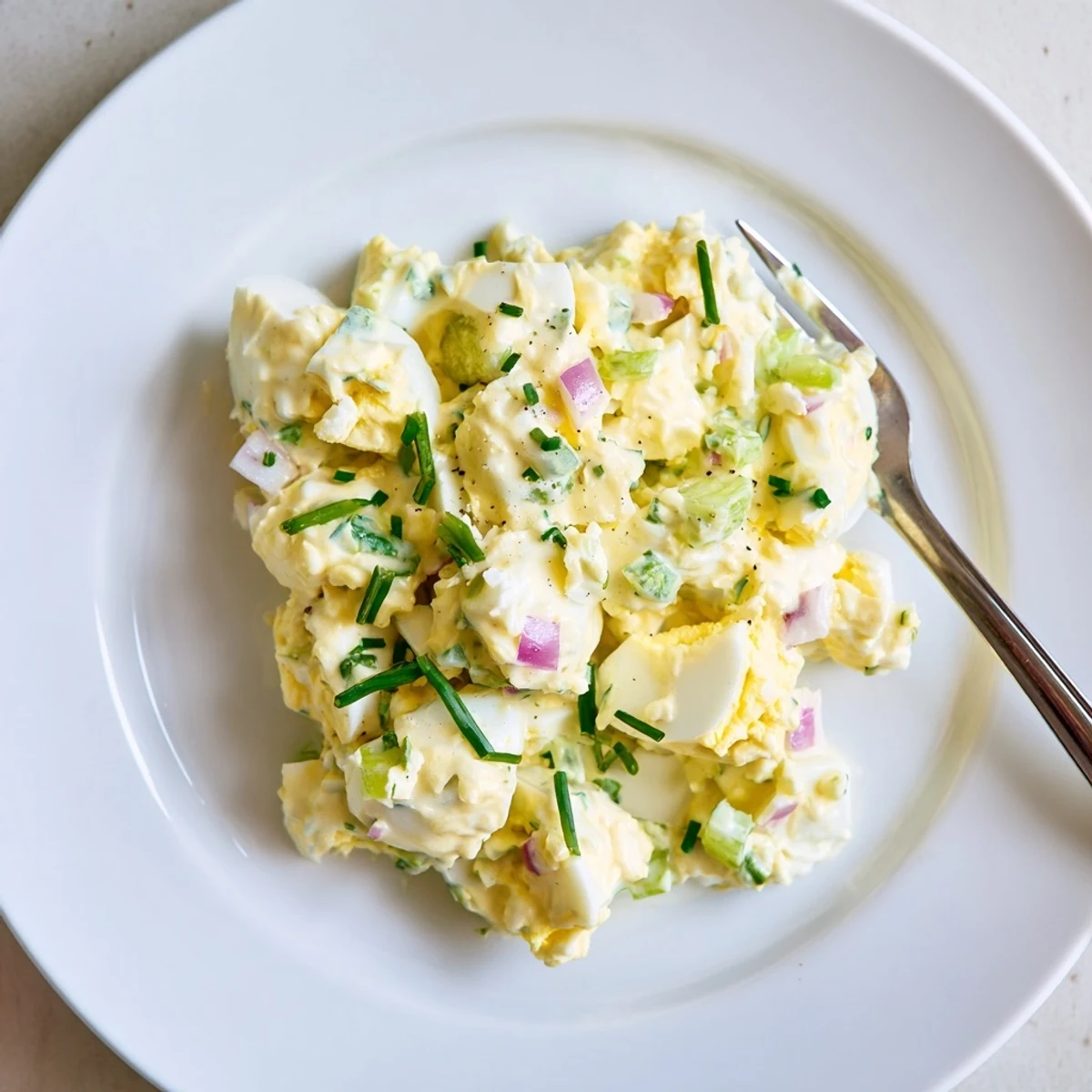 Classic Egg Salad Recipe piled on toasted rye, creamy, speckled with chives