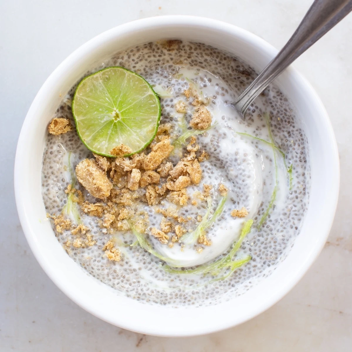 Tangy Key Lime Chia Pudding in glass jars garnished with graham crumbles