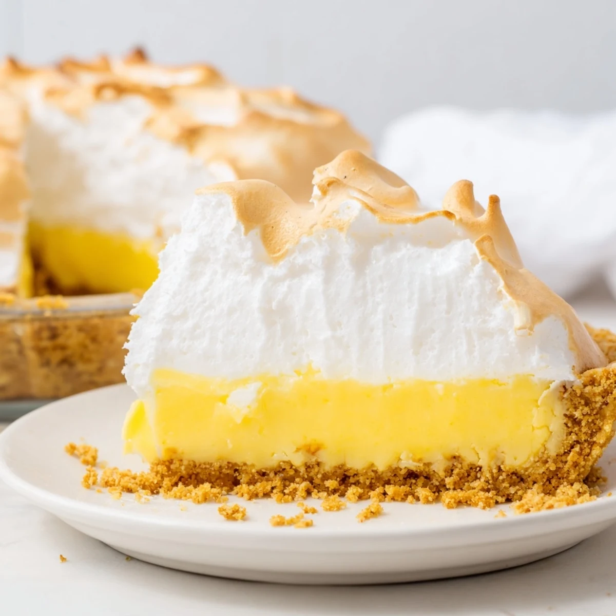 Golden meringue-topped real lemon pie recipe cooling on a wire rack at home