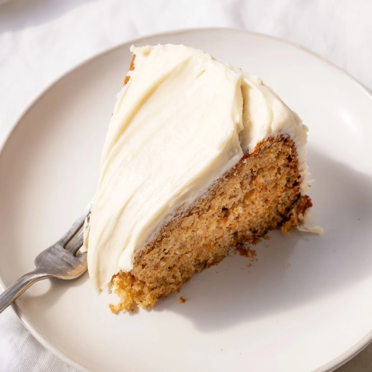Golden Brown Butter Banana Cake topped with swirls of rich cream cheese frosting ready to serve