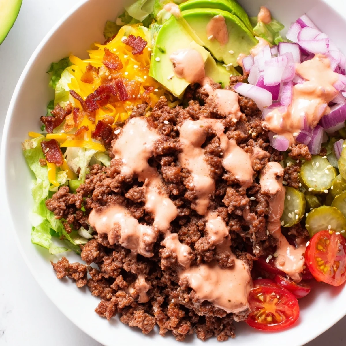Colorful burger bowls featuring juicy ground beef, fresh cherry tomatoes, and creamy drizzle sauce